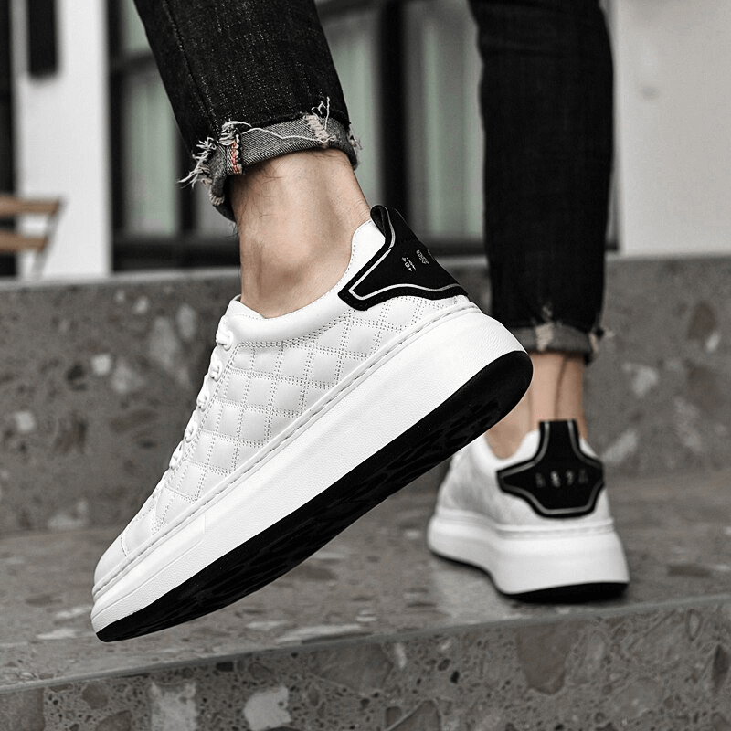 Person wearing fashionable breathable casual men's sneakers, walking confidently on steps, showcasing the black and white design.